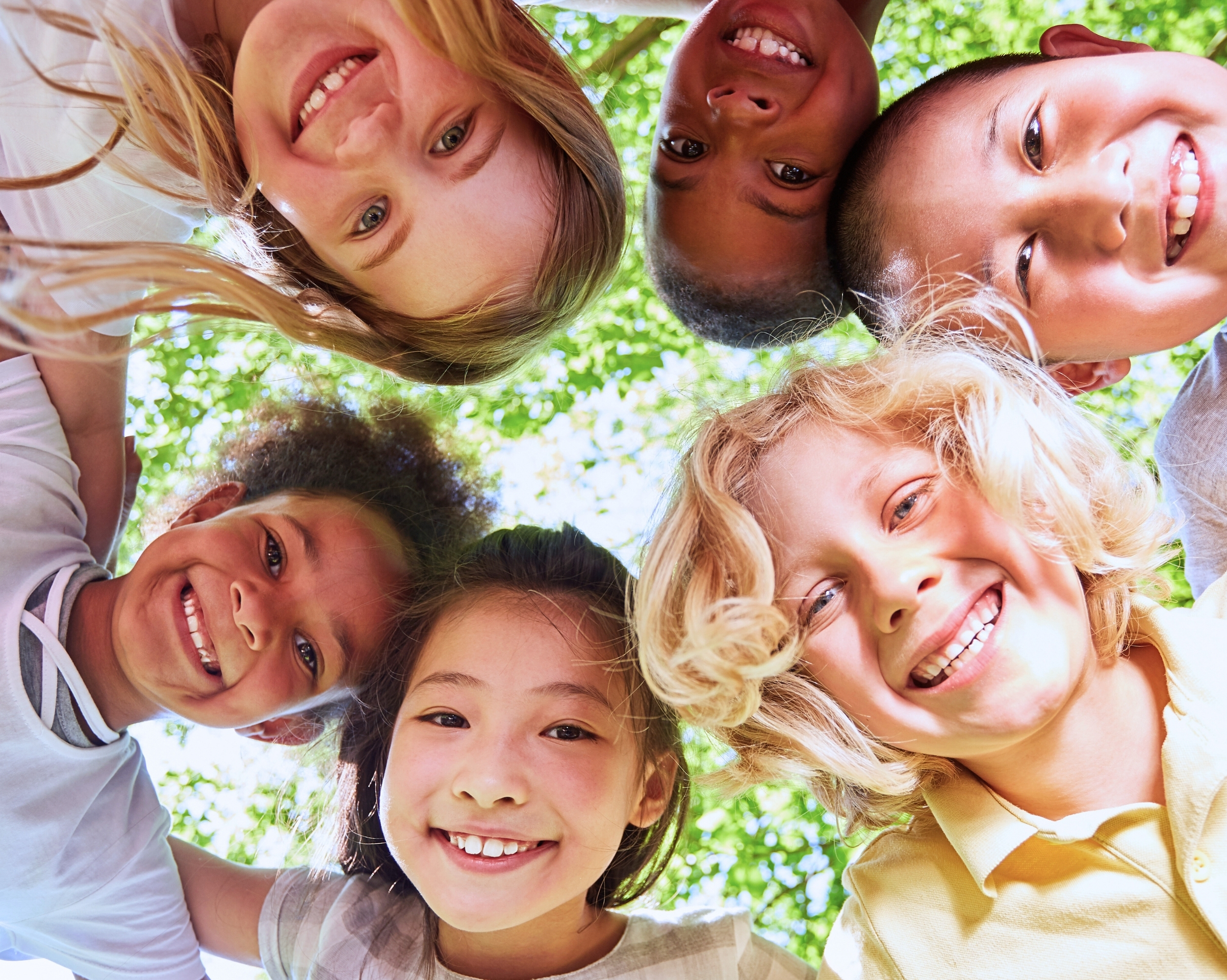 Children with smiling races in a circle representing many cultures and nationalities.